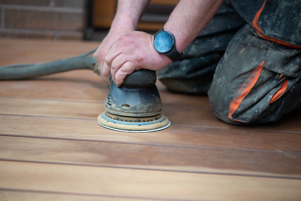man sanding and refinishing hardwood